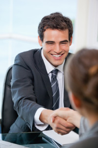 Businessman shaking hands with a client while smiling