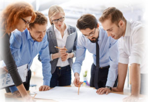 Team of employees studying blueprints at meeting